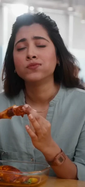 A woman enjoying a piece of chicken