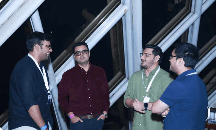 group of four men conversing at a social gathering