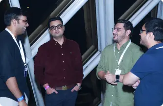 group of four men conversing at a social gathering